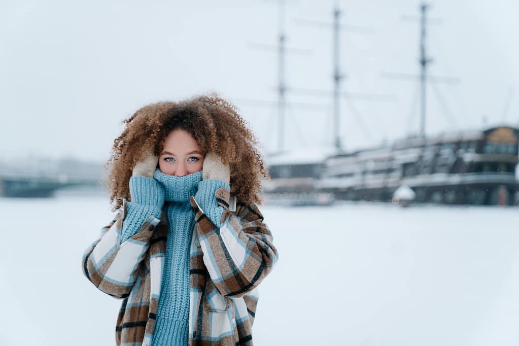 7 Simple Ways to Beat the Winter Blues After the Holidays 1 beat the winter blues. woman with curly hair covering face with blue sweater.