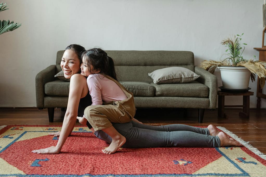Balancing Acts: Real-World Tips for Work-Life Balance for Women Who Do It All 1 photo of girl hugging her mom while doing yoga pose. work-life balance for women