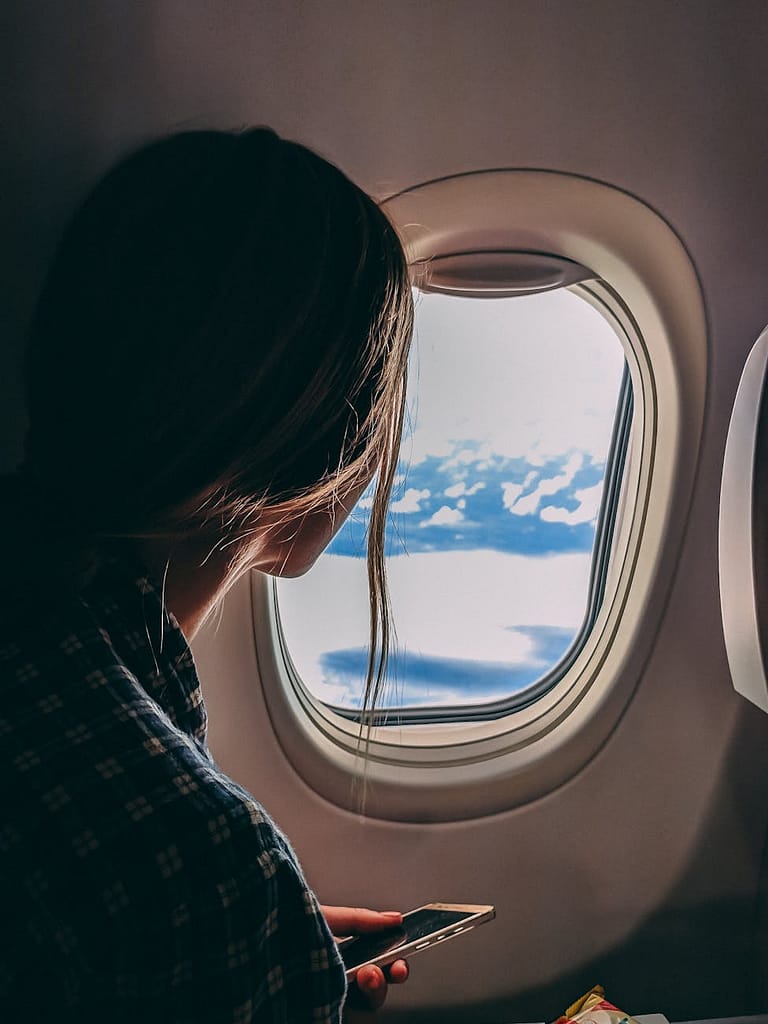 The Truth About Traveler's Fatigue: Disorientation in The Orient 1 person holding smartphone riding airplane - traveler's fatigue